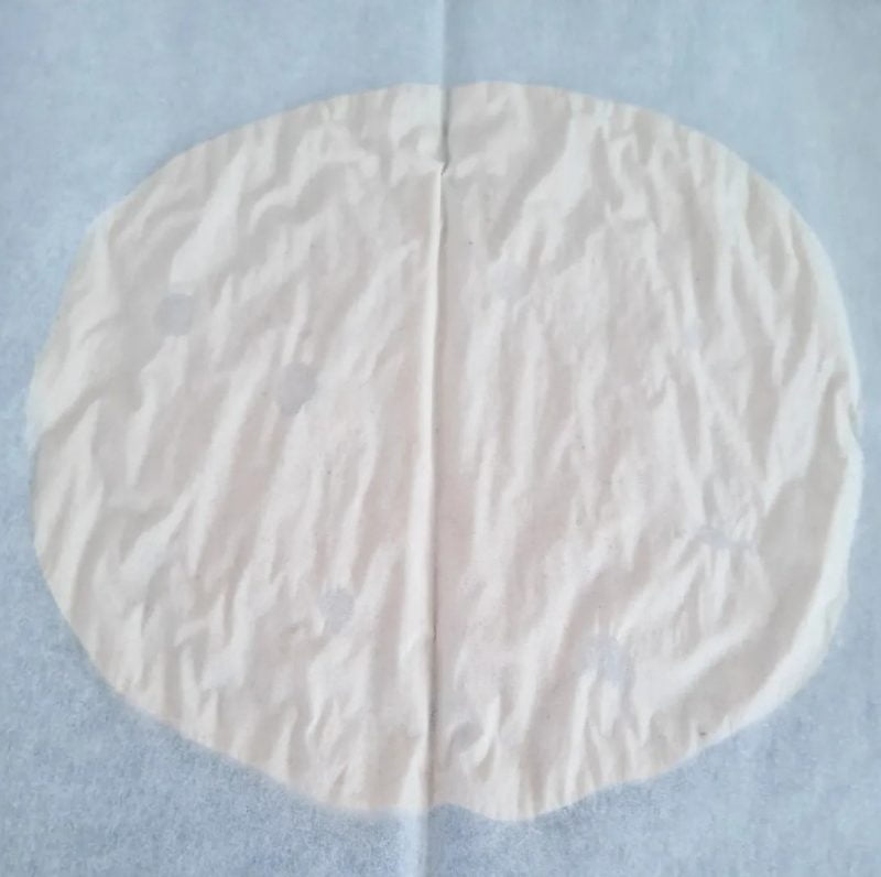 Rund och veckad bakplåtspapper på en vit yta.